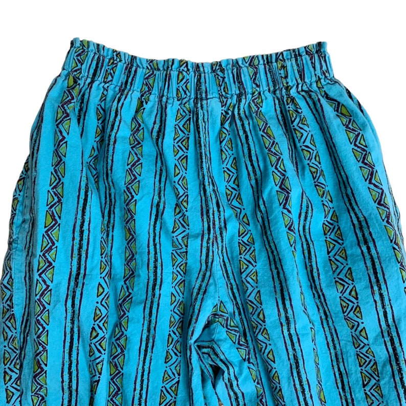 K&ouml;nnte beinhalten: Blaue und gr&uuml;ne gestreifte Hose mit geometrischem Muster. Die Hose hat einen elastischen Bund.