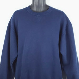 Könnte beinhalten: Ein marineblauer Pullover mit Rundhalsausschnitt.