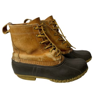 以下が含まれることがあります： 茶色の革製のレースアップブーツで、茶色のゴム製の底があります。ブーツは丈夫な外観で、高品質の素材で作られています。