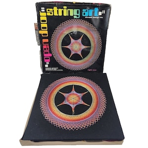 Może przedstawiać: Zestaw do projektowania nici "String Art" w stylu vintage. Pudełko i gotowe dzieło sztuki przedstawiają okrągły wzór z kształtem gwiazdy pośrodku, wykorzystując gradient kolorów. Pudełko jest czarne z kolorowym tekstem i słowami "open door".
