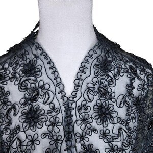 May include: Black beaded lace fabric with a floral design. The lace is delicate and intricate, with small black beads sewn throughout.