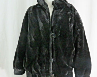 May include: A black faux fur jacket with a button closure. The jacket has a collar and long sleeves.