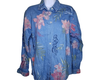 May include: A blue denim shirt with a floral print. The shirt has a button-up front and long sleeves.