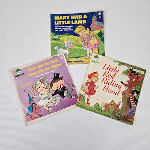 May include: Three vintage children's record albums. The album covers feature illustrations of nursery rhymes and fairy tales, including "Mary Had a Little Lamb," "Little Red Riding Hood," and "Get Me to the Church on Time."