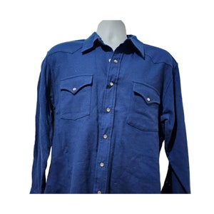 May include: A long-sleeved, navy blue button-down shirt with two chest pockets and a snap closure.