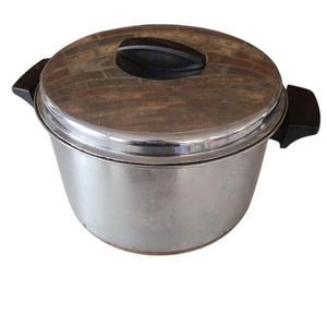 以下が含まれることがあります： 蓋と2つの黒いハンドルが付いたステンレス製の調理鍋。蓋の上部には黒いハンドルが付いています。鍋は丸く、光沢のある金属仕上げです。鍋は調理と食品の準備のために設計されています。