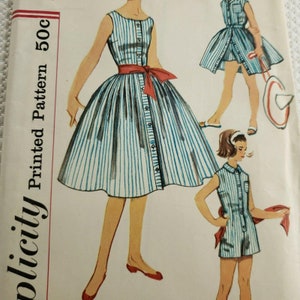 Op de afbeelding: Vintage Simplicity naaipatroon met illustraties van gestreepte jurken. De hoofdafbeelding toont een jurk met een rode riem. Het patroon bevat een prijskaartje van 50c. De jurken hebben een ontwerp met knopen.