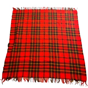 May include: Red, black, and yellow plaid throw blanket with fringe on all sides.