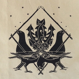 May include: A black and white linocut print featuring two birds facing each other, with a dandelion and star design. The birds are singing, and the image is set against a cream-colored background.