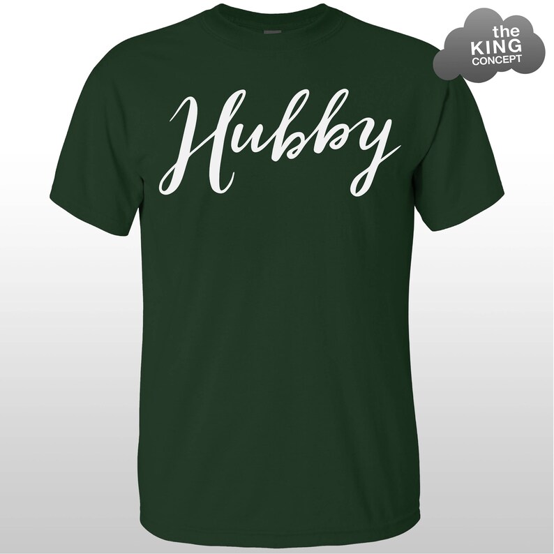 Może przedstawiać: Zielony T-shirt z napisem "Hubby" napisanym białym, ozdobnym pismem.