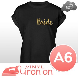 May include: Black t-shirt with gold vinyl iron-on lettering that says "Bride" with a small heart above the "e". The t-shirt is size A6.