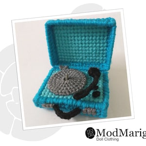 May include: A blue and grey crocheted record player with the lid open. The record player is small enough to be a toy for a doll.