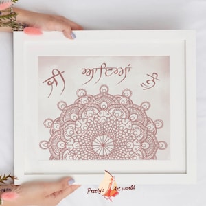 May include: A white framed print with a pink mandala design and the text "Shree" and "Waheguru" in a pink script. The background is a light pink watercolor wash.
