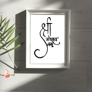 May include: A white framed print with black calligraphy that reads "Shri Ganeshay Namah".