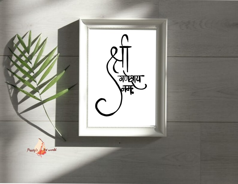 May include: A white framed print with black calligraphy that reads "Shri Ganeshay Namah".