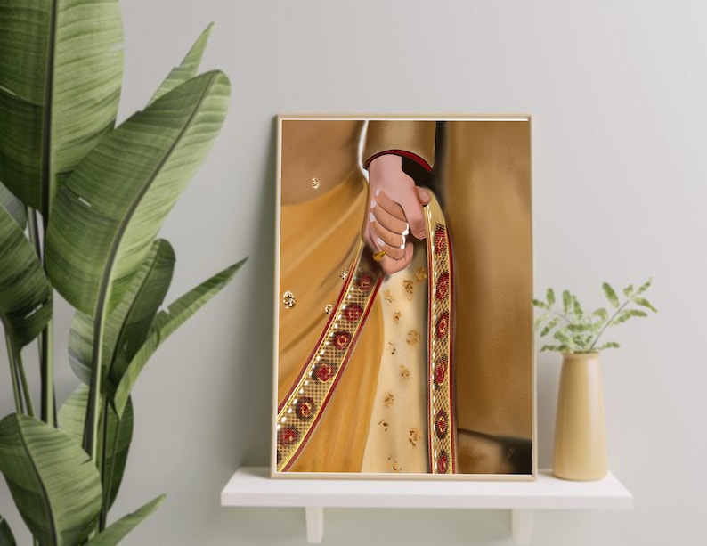 May include: A close-up of a couple's hands holding each other. The woman is wearing a gold and red embroidered sari. The man is wearing a gold and red embroidered sherwani.