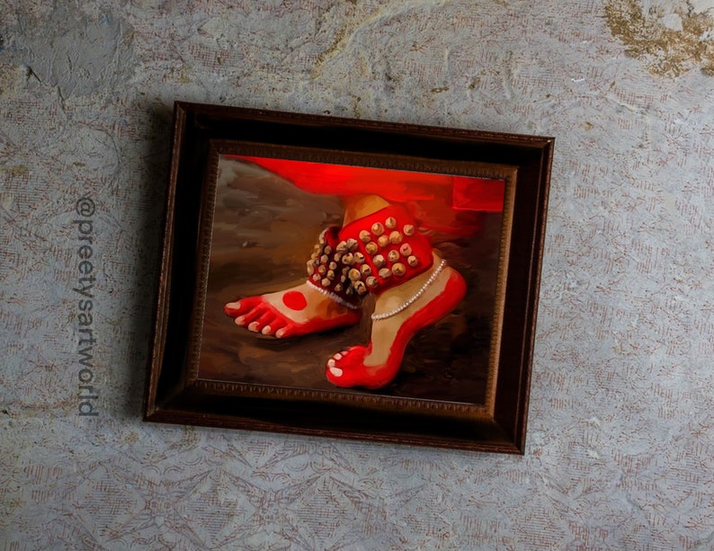 May include: A framed painting of a foot wearing a red anklet with gold bells. The foot is painted in a red color with a white dot on the big toe.