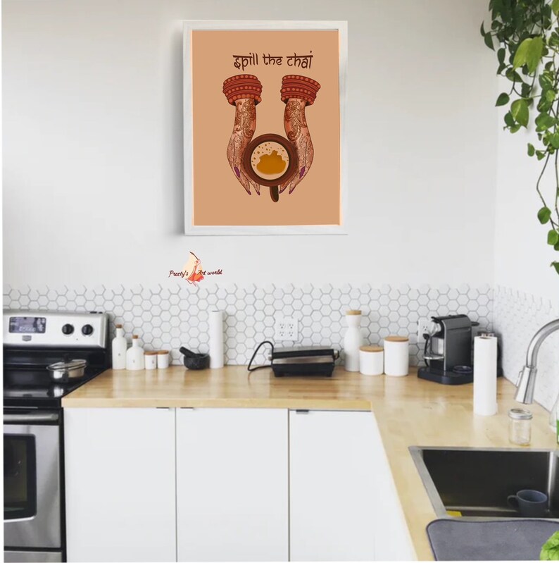 Puede incluir: Impresi&oacute;n art&iacute;stica enmarcada con la frase "Spill the Chai" sobre una taza de chai sostenida por manos adornadas con dise&ntilde;os de henna. La obra de arte est&aacute; sobre un fondo melocot&oacute;n y enmarcada en blanco.