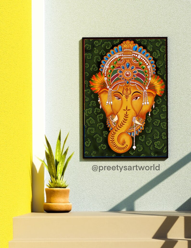 May include: A traditional Indian painting of the Hindu deity Ganesha, depicted with a golden head and trunk against a green background with swirling patterns. The painting is framed in black and features intricate details in the deity's headdress and jewelry.