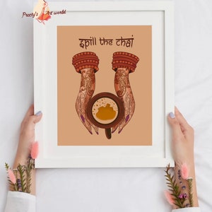 Puede incluir: Una impresi&oacute;n art&iacute;stica enmarcada que presenta una ilustraci&oacute;n de manos adornadas con henna sosteniendo una taza de chai. El texto "Spill the chai" est&aacute; encima de la taza. La obra de arte est&aacute; sobre un fondo beige.