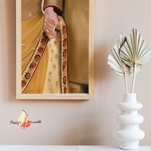 May include: A framed illustration of a couple's hands, the woman's hand is adorned with a gold ring and a traditional Indian saree with gold and red embroidery.