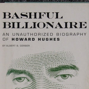 May include: Book cover with the title "Bashful Billionaire: An Unauthorized Biography of Howard Hughes" by Albert B. Gerber. The cover features a green line art illustration of Howard Hughes's face.