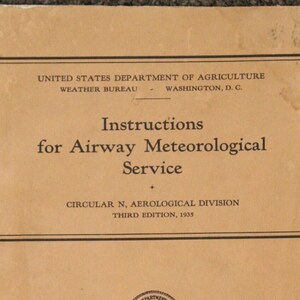 May include: A tan-colored booklet with the title "Instructions for Airway Meteorological Service" printed in black. The booklet is from the United States Department of Agriculture, Weather Bureau, Washington, D.C. and is the third edition from 1935.