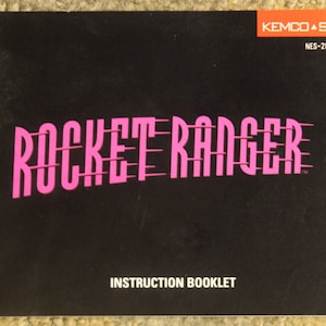 May include: A black and white instruction booklet for the NES video game Rocket Ranger. The title of the game is in pink letters with a white outline. The game is published by Kemco and Seika.