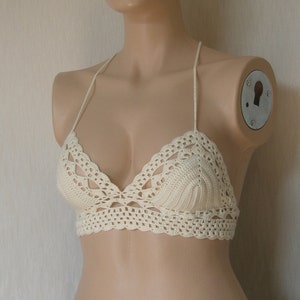May include: A white crocheted bikini top with a delicate, lacy design.