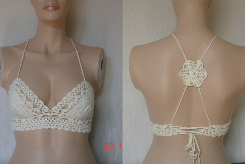 May include: A white crocheted halter top with a floral design on the back. The top is made with a delicate crochet stitch and has a relaxed fit.