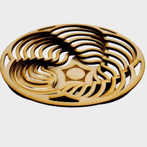 Puede incluir: Un cuenco de madera con un diseño único e intrincado. El cuenco está hecho de múltiples capas de madera, creando un patrón de remolino. El cuenco es de color marrón claro.