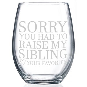 May include: A clear glass stemless wine glass with the text "SORRY YOU HAD TO RAISE MY SIBLING YOUR FAVORITE" etched on the front.