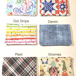 May include: Six rectangular fabric card holders arranged in two columns. Patterns include a colorful swirl, a red, white, and blue star quilt design labeled Liberty, a multi-colored dot stripe, a blue denim texture, a black and white plaid, and a gnome print.