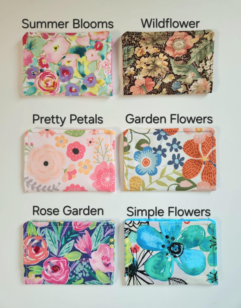 May include: Six rectangular fabric pouches with floral patterns labeled Summer Blooms, Wildflower, Pretty Petals, Garden Flowers, Rose Garden, and Simple Flowers. Each pouch features distinct colorful botanical prints on a white or dark background.