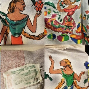 May include: A white fabric with a colorful Mexican folk art design featuring women in traditional clothing and floral patterns. The fabric has a label that reads "Mexican Traditions".