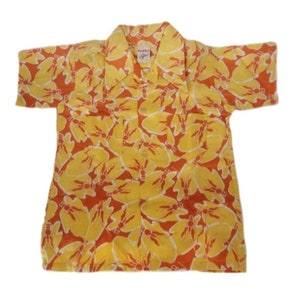 May include: A short-sleeved button-down shirt with a yellow and orange floral pattern. The shirt has a collar and two pockets.