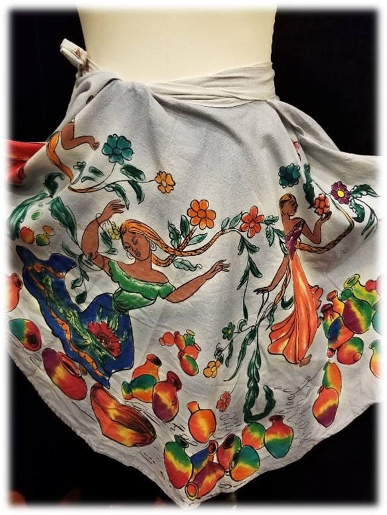 May include: A white cotton skirt with a colorful floral print featuring women and pottery. The skirt has a tie closure at the waist.
