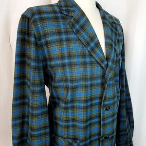 May include: A blue, green, and black plaid blazer with a single button closure and a patch pocket on the left side. The blazer is on a mannequin.