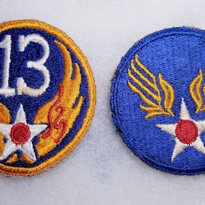 May include: Two embroidered patches, one blue with a white star and gold wings, the other blue with a white star, gold wings, and the number 13.