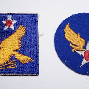 May include: Two vintage US Air Force patches. The first patch is a square with a blue background, a white star with a red center, and a yellow eagle with a red beak and talons. The second patch is a circle with a blue background, a white star with a red center, and two yellow wings.