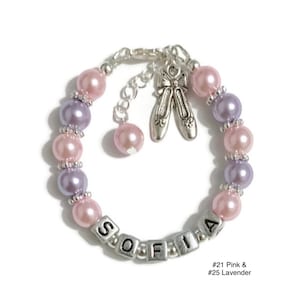 May include: A pink and lavender beaded bracelet with a silver charm of ballet shoes and a silver name charm that says "SOFIA".