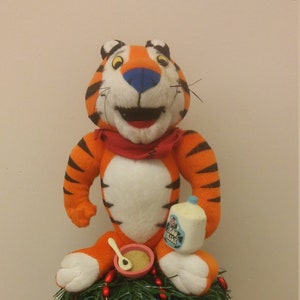 6 inch plush breakfast loving Tony the Tiger atop a 6 inch shatterproof ornament ball