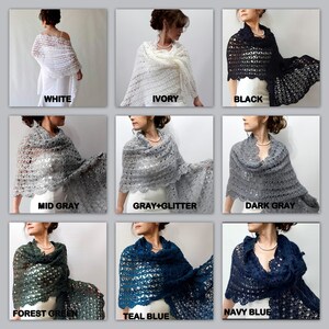 Op de afbeelding: Een collectie gehaakte shawls in verschillende kleuren, waaronder wit, ivoor, zwart, middengrijs, grijs met glitter, donkergrijs, bosgroen, tealblauw en marineblauw. De shawls worden getoond gedrapeerd over modellen.
