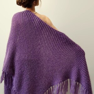 May include: A purple knitted shawl with fringe on the bottom edge.