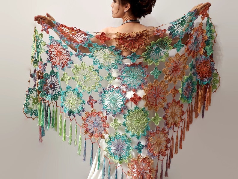May include: A colorful crochet shawl with a fringed edge. The shawl is made with a variety of colors, including green, blue, orange, and purple. The shawl is crocheted in a delicate pattern of flowers.