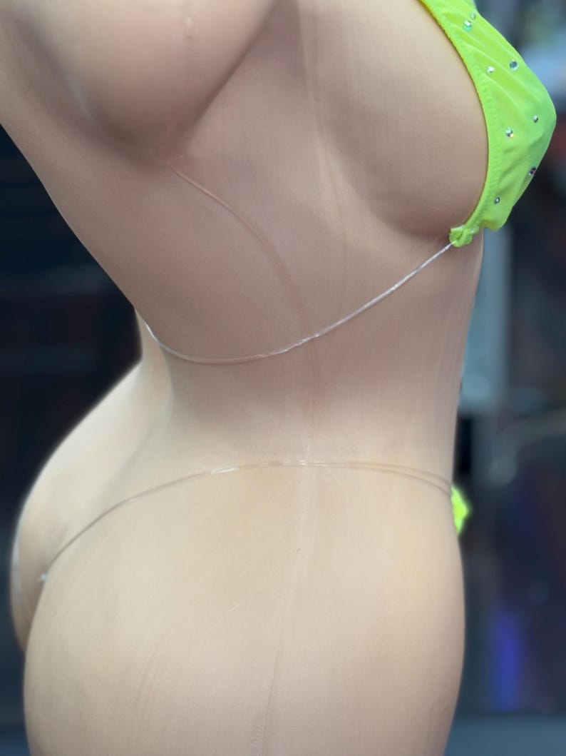 Op de afbeelding: Een neon-groene bikini top met strass. De top heeft doorzichtige bandjes die aan de achterkant van de nek vastgebonden worden.