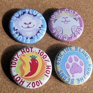 May include: Four round buttons with colourful designs and text. The first button is blue with white text that reads "100% FLUFF 100%" and features a white fluffy cat with a pink nose. The second button is purple with white text that reads "100% CUTE 100%" and features a white cat with closed eyes. The third button is yellow with red text that reads "100% HOT 100% HOT 100%" and features a red chili pepper with flames. The fourth button is blue with yellow text that reads "FOR THE BEANS FOR THE BEANS" and features a purple paw print.