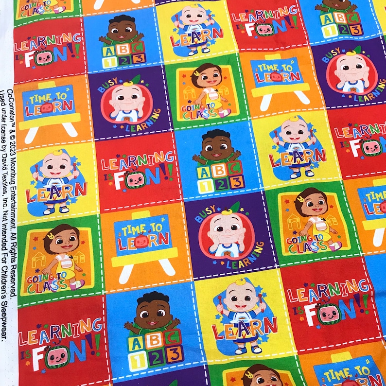 May include: A colorful fabric with a repeating pattern of a cartoon character learning the alphabet, counting, and going to class. The fabric features the text "Learning is Fun!" and "Time to Learn!" in a bright, playful font.
