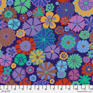 May include: A colourful fabric with a dense floral pattern. The design features flowers in shades of blue, purple, orange, green, and brown against a dark blue background. The flowers vary in size and shape, creating a lively print. The fabric has a ruler along the bottom with the text "Free Spirit" and "freespiritfabrics.com".