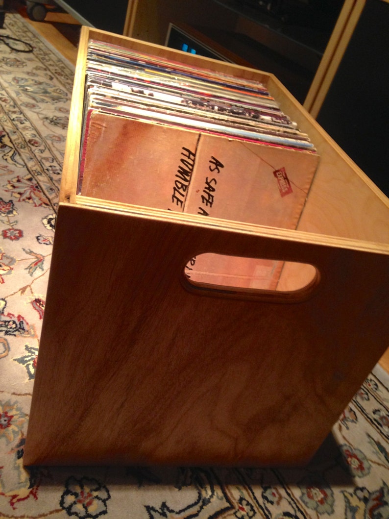 May include: A wooden crate filled with vinyl records. The crate has a cutout handle and the text "As Safe A Humble" is visible on the top of the crate.